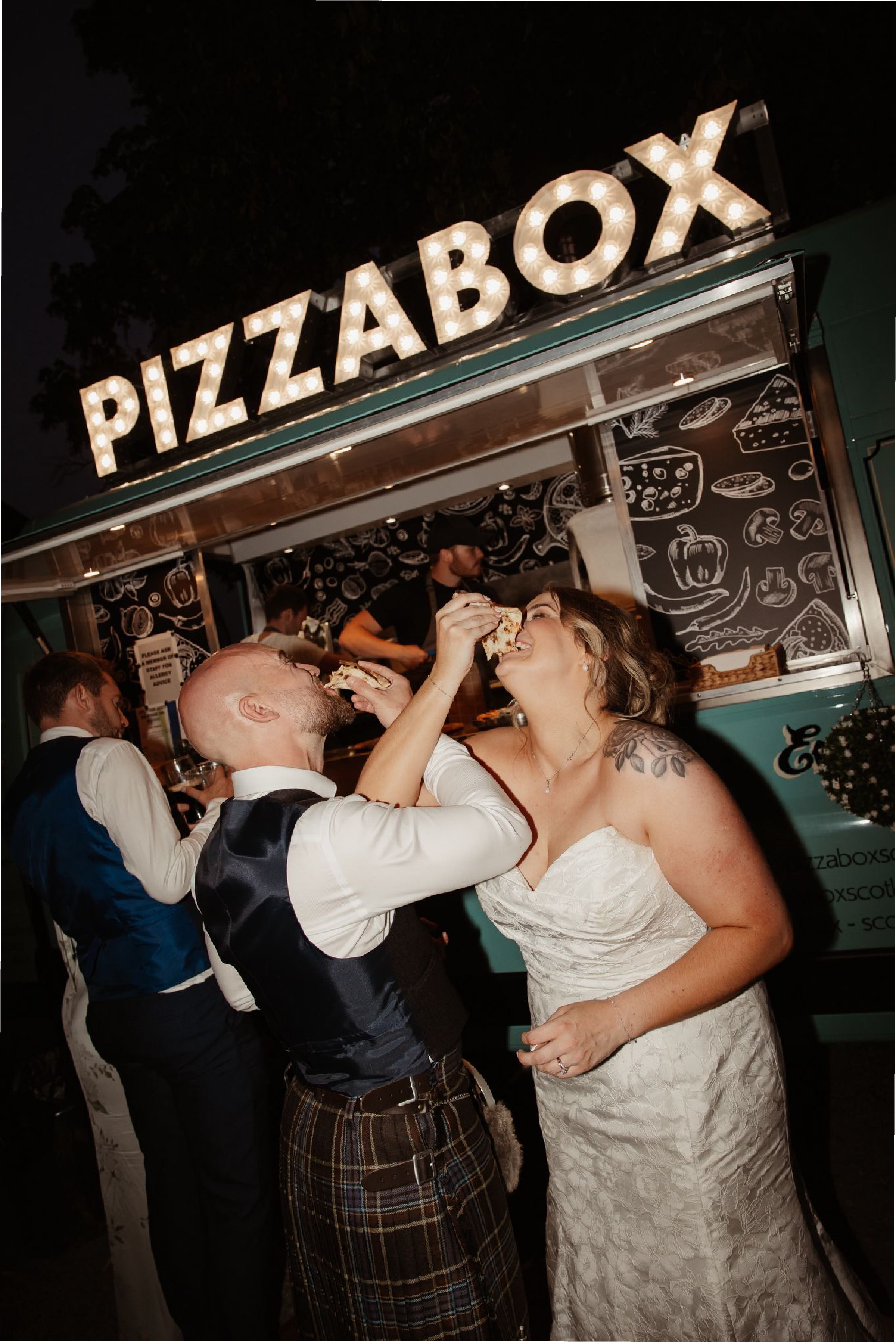 Guests enjoying pizza at a wedding celebration